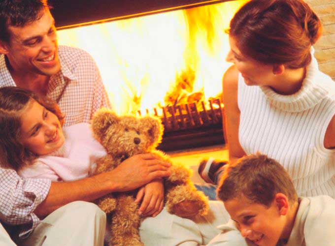 Die Familie vor dem holzbefeuerten Kamin 